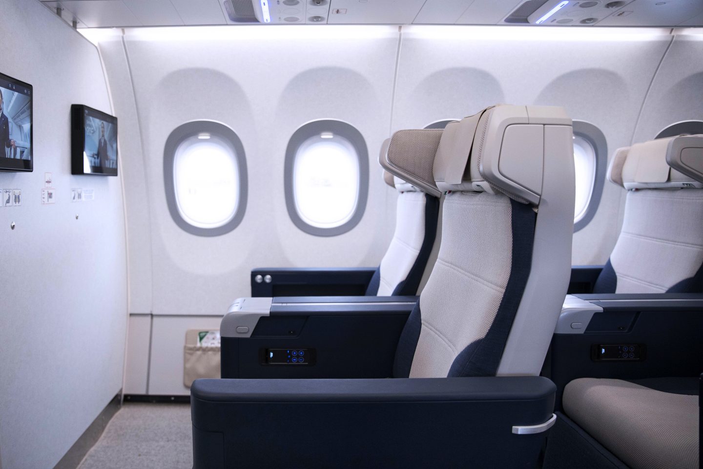 Πρώτη σειρά καθισμάτων Premium Economy με επιπλέον χώρο για τα πόδια και επιτοίχιες οθόνες τηλεόρασης.