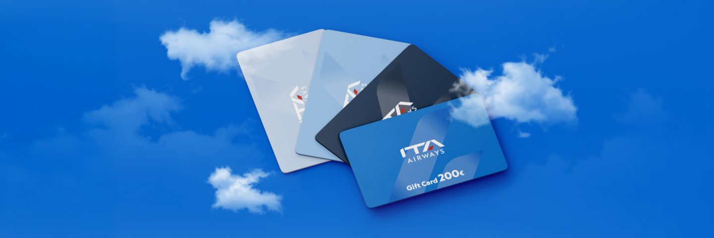 Four ITA Airways Gift Cards arranged on a blue background with clouds.