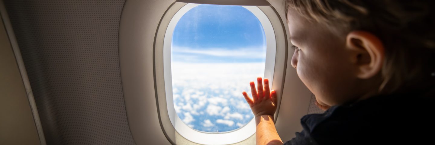 A child looking out of an aircraft window.