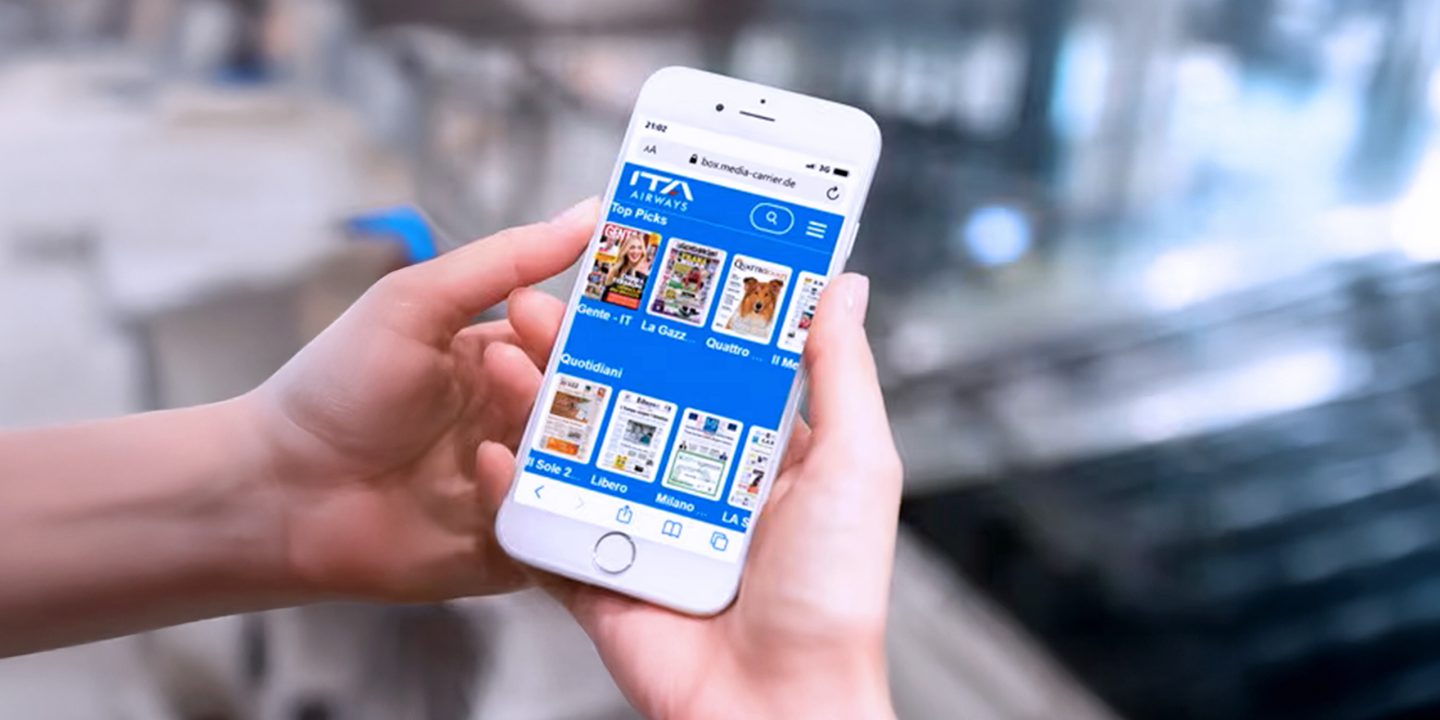 Une personne tenant un smartphone affichant l’application ITA Airways.