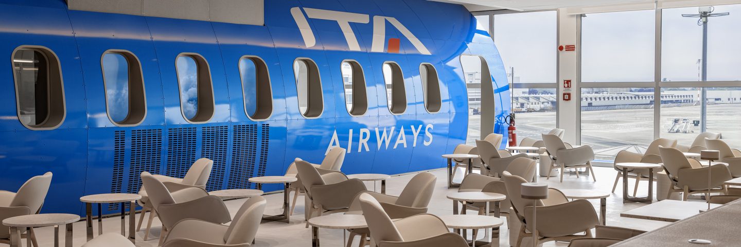 Intérieur du salon Runway à Milan Linate, avec un mur ressemblant à un avion ITA Airways.