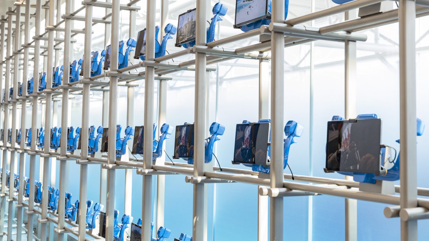 Structure with various rows of tablets mounted on it.