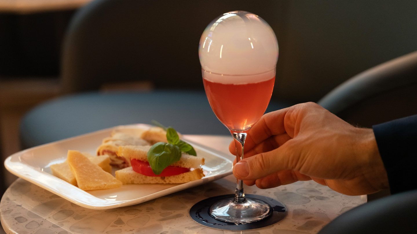 A drink and a plate of snacks placed on a small table.