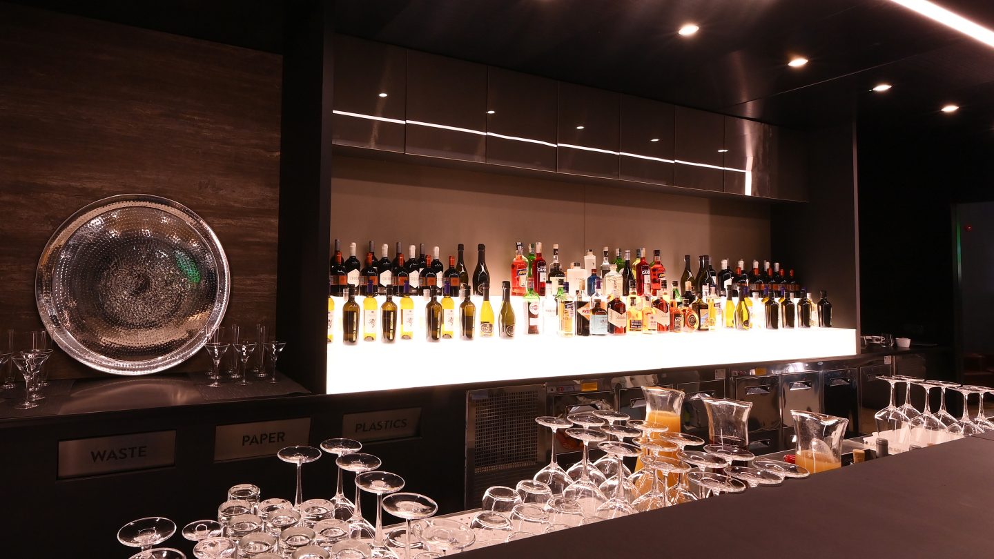 Comptoir de bar avec bouteilles et verres exposés.