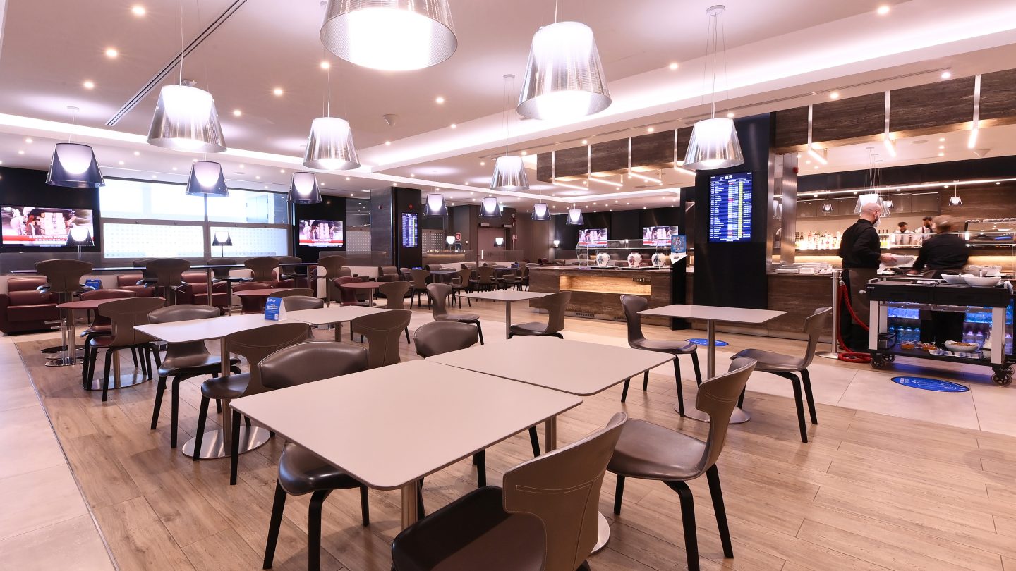 Espace salon avec des tables, des chaises et un bar en arrière-plan.