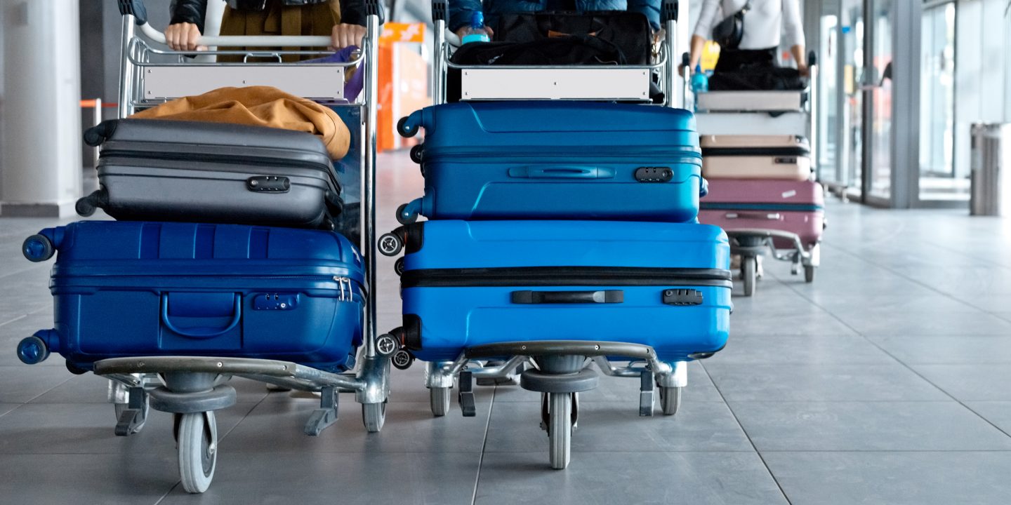 Koffer auf Gepäckwagen in einem Flughafen.