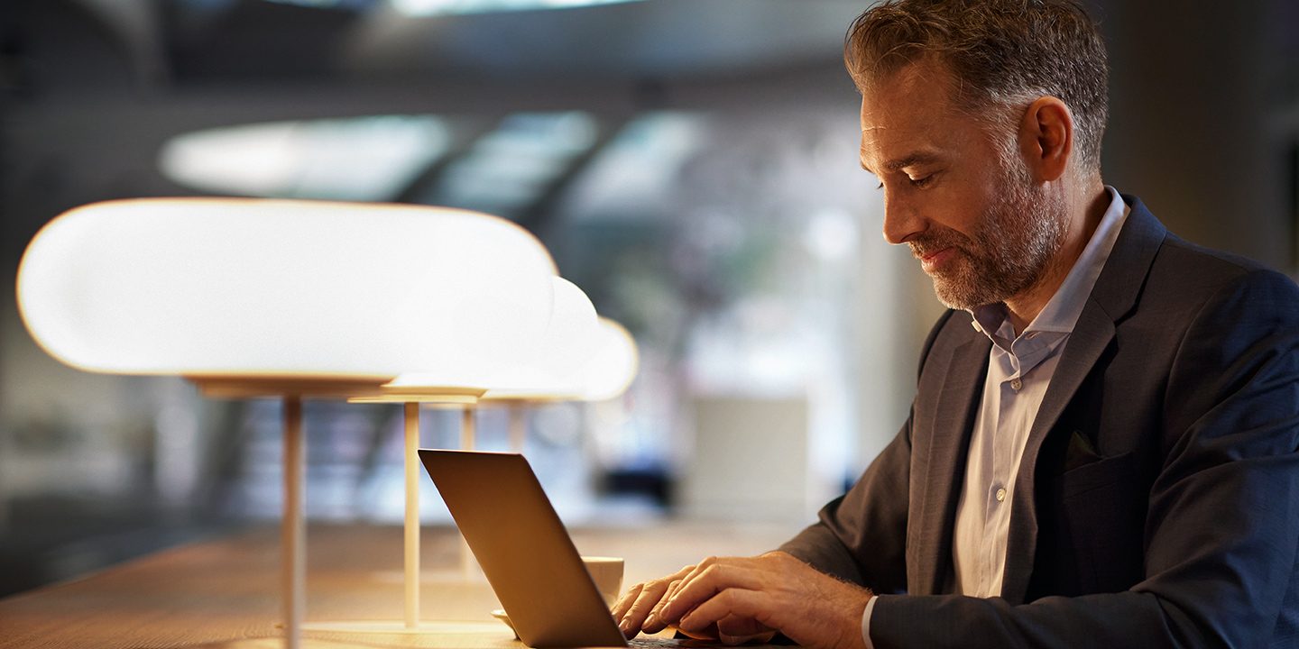 Businessman at a computer on a modern, well-lit desk.