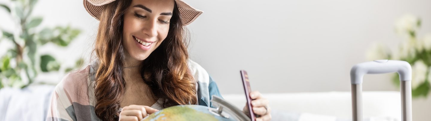 Woman smiling while looking at the globe.