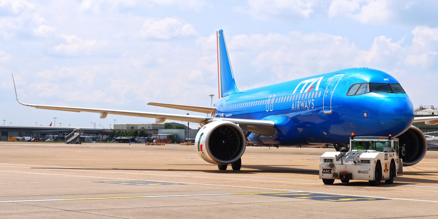 Ein Flugzeug von ITA Airways steht im Flughafen neben einem Servicefahrzeug.