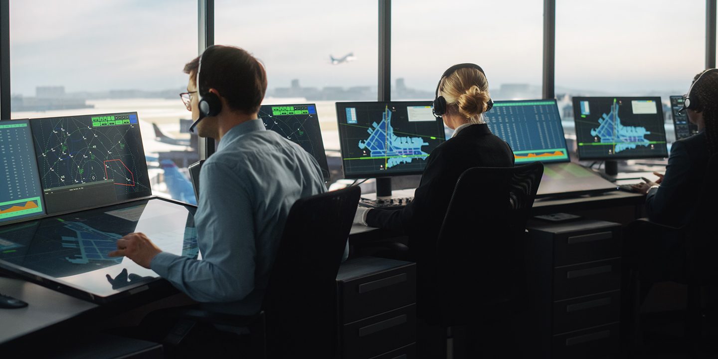 Controllori di volo al lavoro in una torre di controllo aeroportuale.