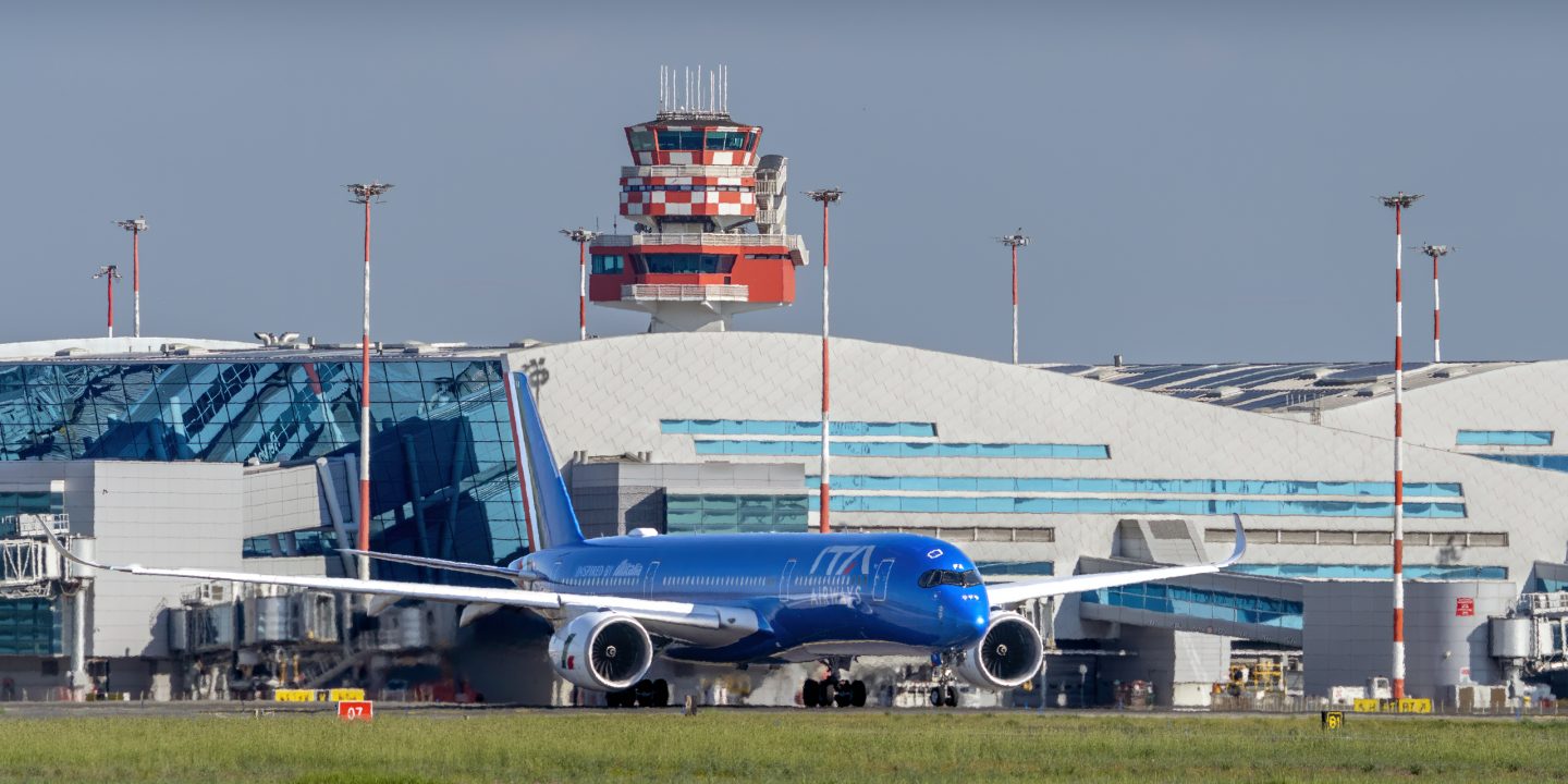 Een vliegtuig van ITA Airways op de grond voor de luchthaventerminal.