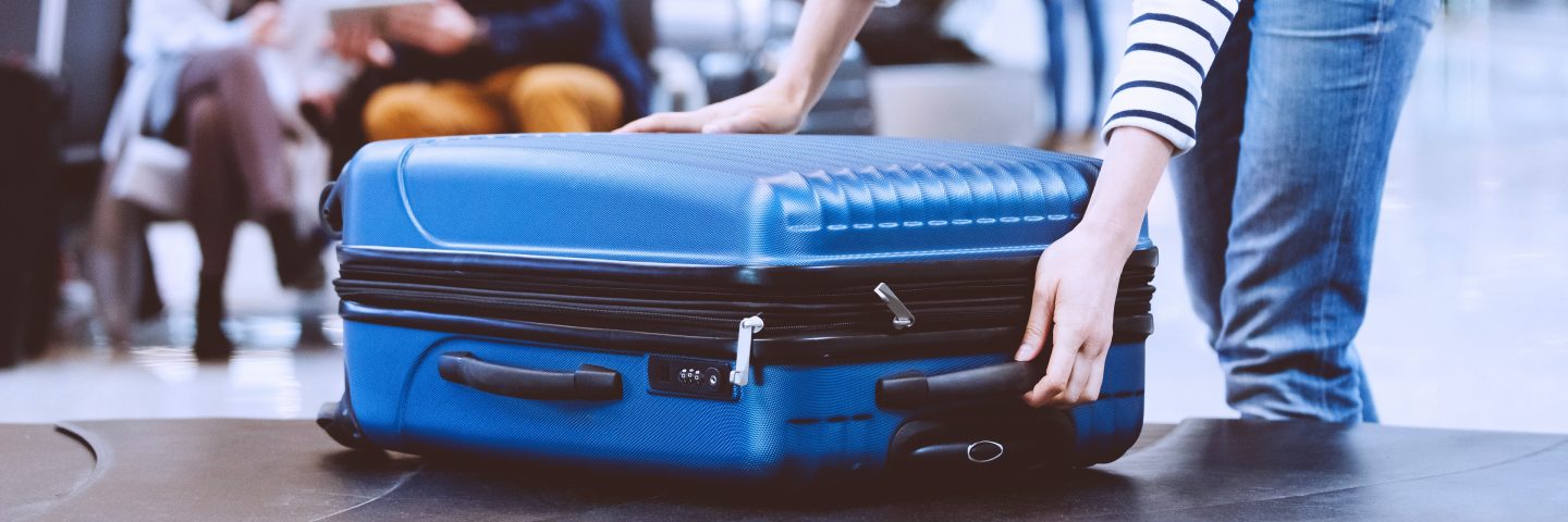 A passenger collecting her luggage from the conveyor belt.