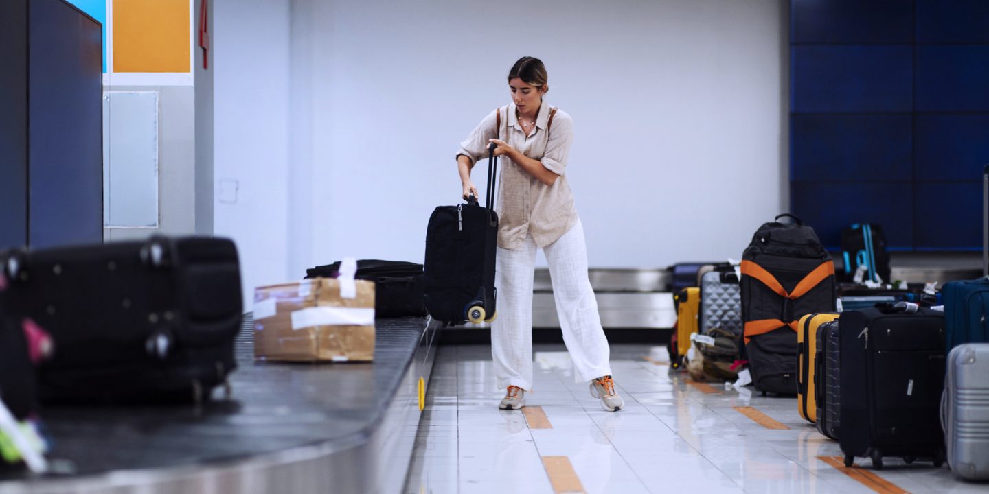 A passenger collecting her baggage from the carousel at the airport.