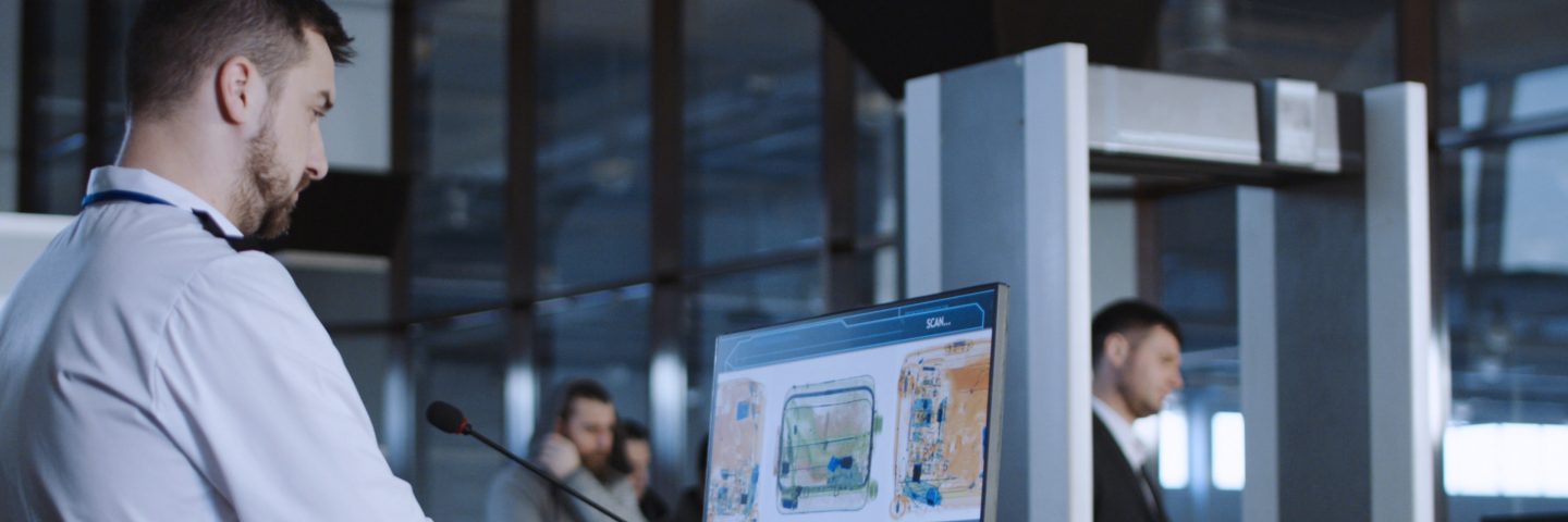 Airport associate checking security lanes monitors