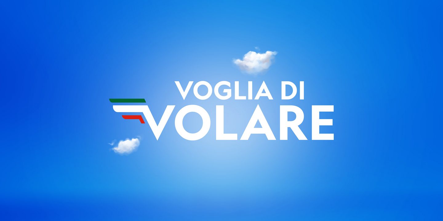 De woorden ‘Voglia di Volare’ op een blauwe achtergrond met wolken en het logo van ITA Airways.