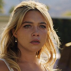 Florence Pugh com uma expressão preocupada e triste olhando para o lado.