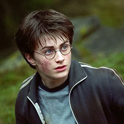 Harry Potter com óculos redondos e um corte na bochecha parecendo assustado.
