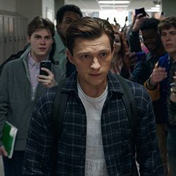 Tom Holland caminhando por um corredor escolar, cercado por multidões de estudantes.