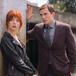 Taylor-Joy e Nicholas Hoult parecendo preocupados, do lado de fora.