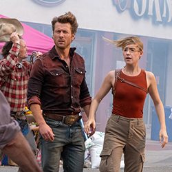 Glen Powell e Daisy Edgar-Jones assustados em uma rua empoeirada.