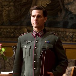 Tom Cruise em um uniforme militar, segurando uma pasta em um ambiente interno.