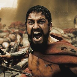 Guerreiro barbudo em uma capa vermelha gritando ferozmente durante uma cena de batalha.
