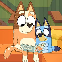 Desenho em estilo de animação de um cão Blue Heeler lendo um livro para um filhote laranja.