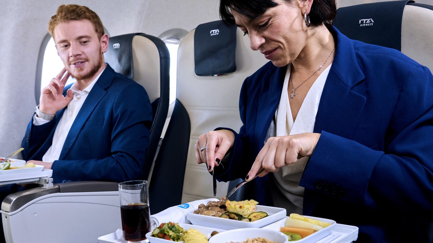 Two passengers eating a meal served in Business Class.
