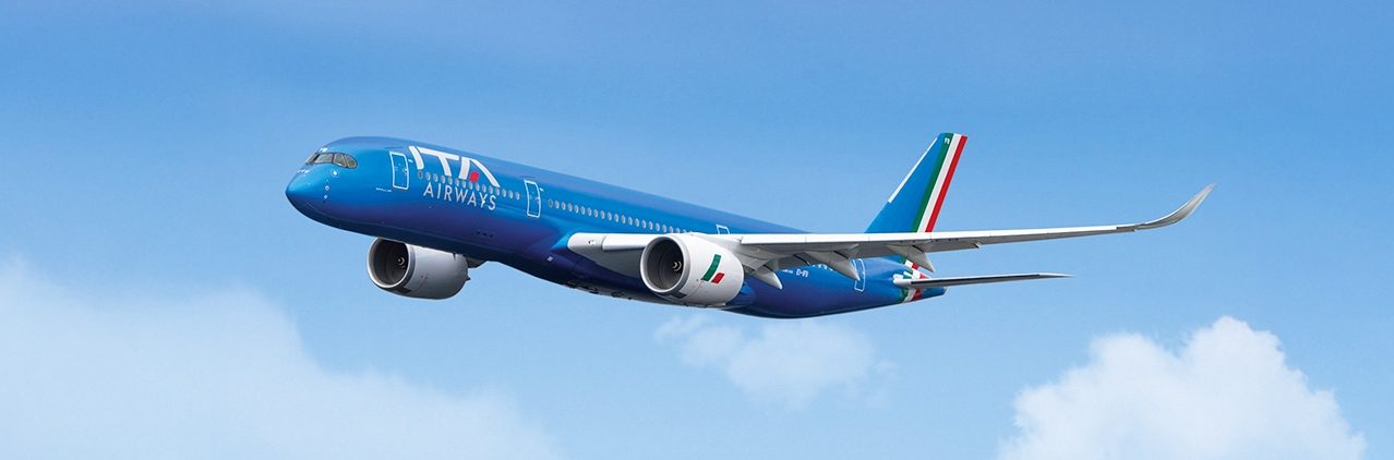 An ITA Airways plane flying in a blue sky.