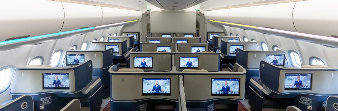 Interior of an airplane with numerous screens, highlighting the upgrade option to enhance the travel experience.