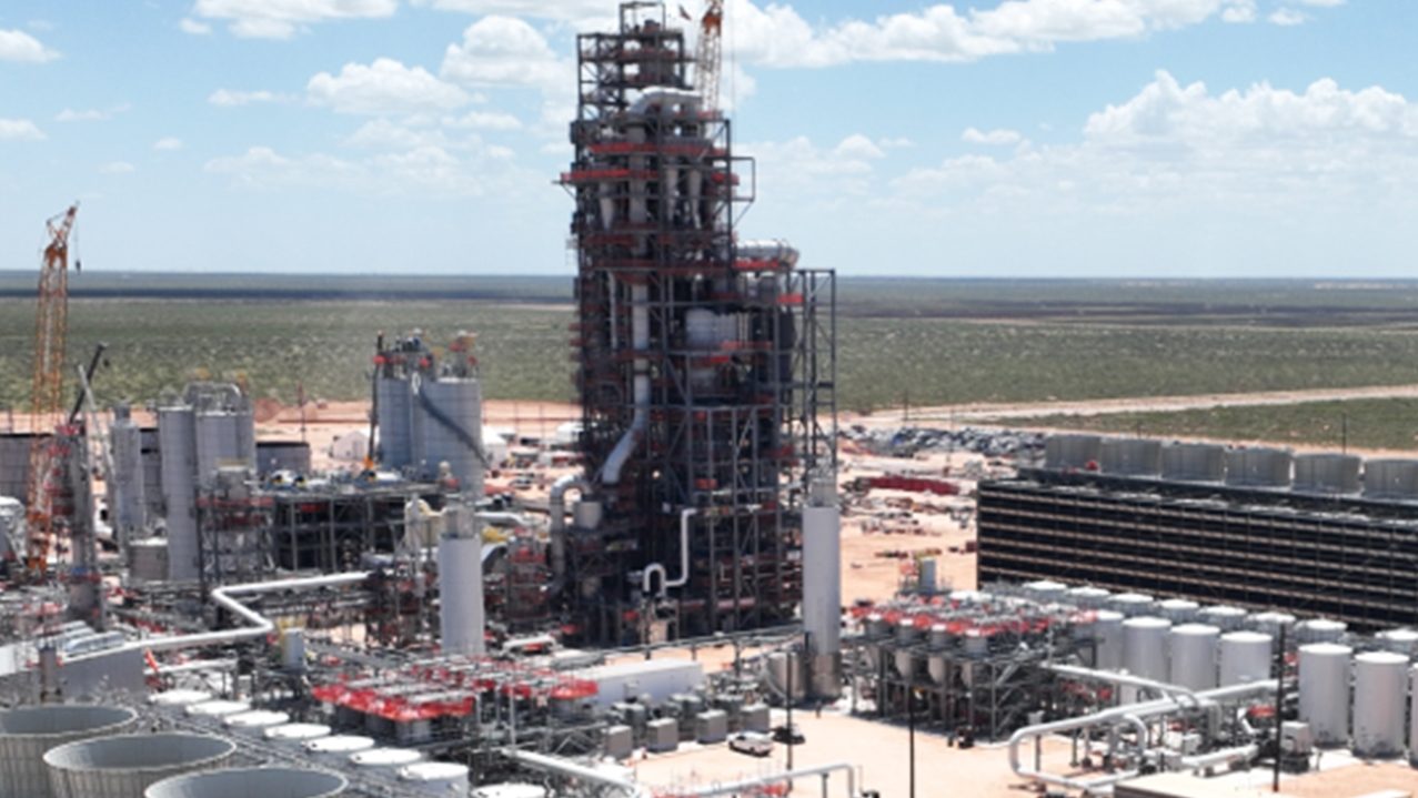 Raffineria di petrolio con diversi grandi serbatoi in vista.