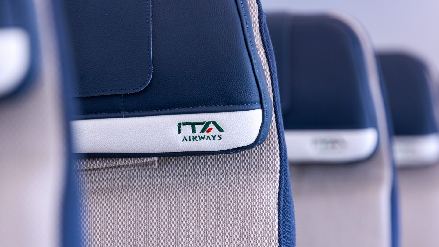 Gros plan du logo ITA Airways brodé sur l’appuie-tête d’un siège.