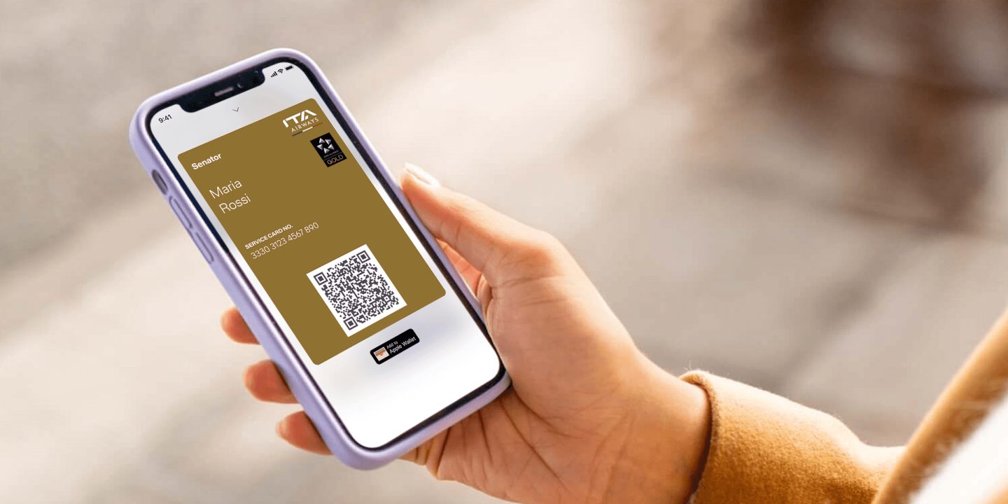 Hand holding a smartphone displaying a digital pass with a QR code.