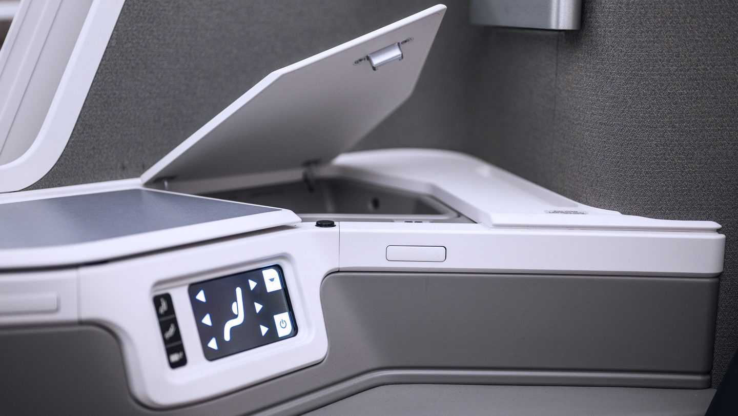 Pulsanti del sedile di Business Class e vani portaoggetti integrati.